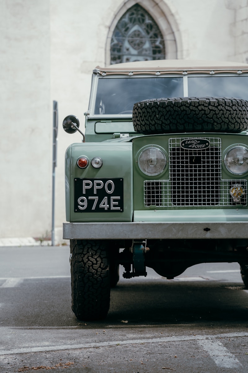 A vintage green land rover parked outdoors